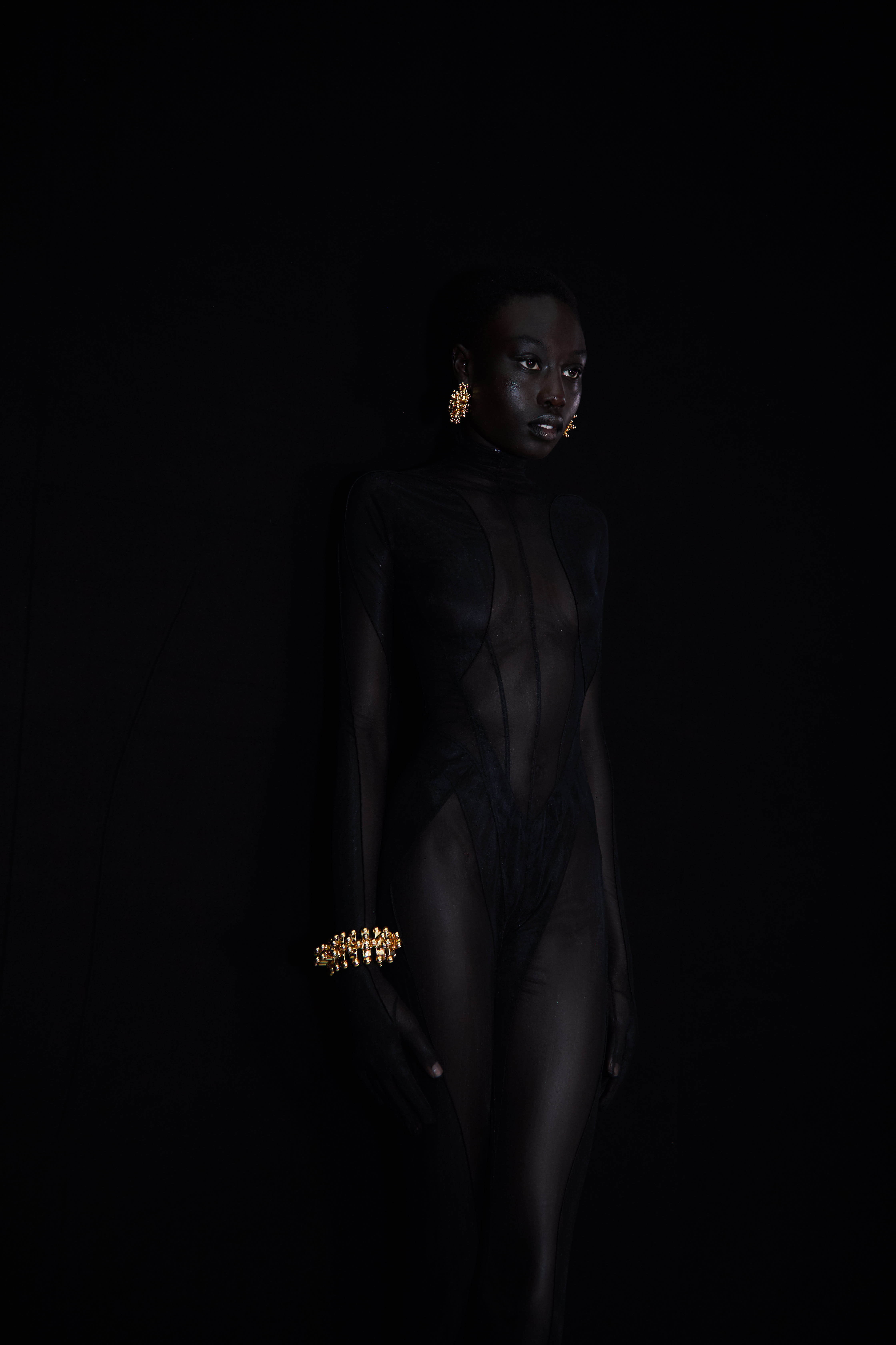 model in black outfit with gold earrings and bracelet