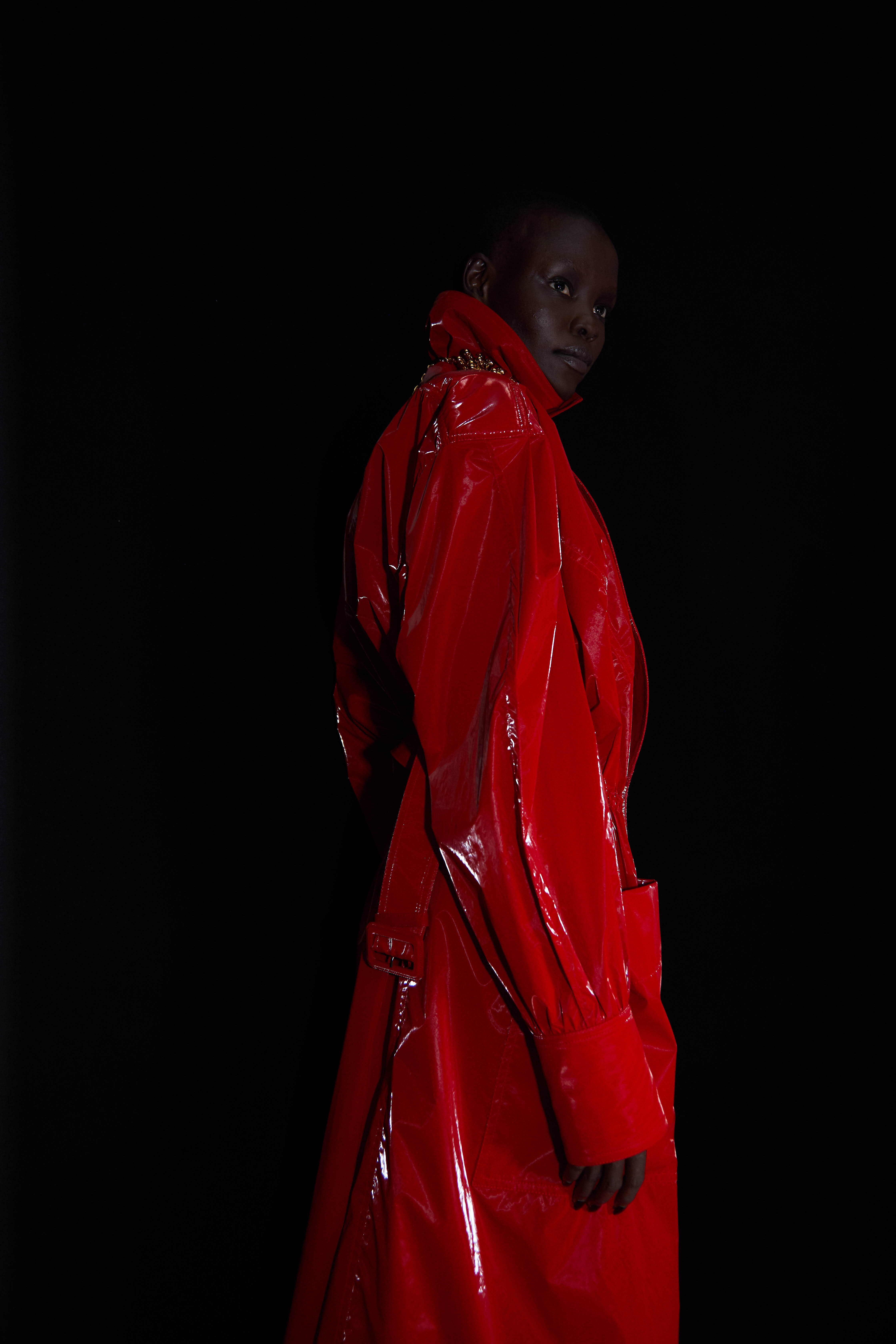 Model in long red leather Mugler trench coat