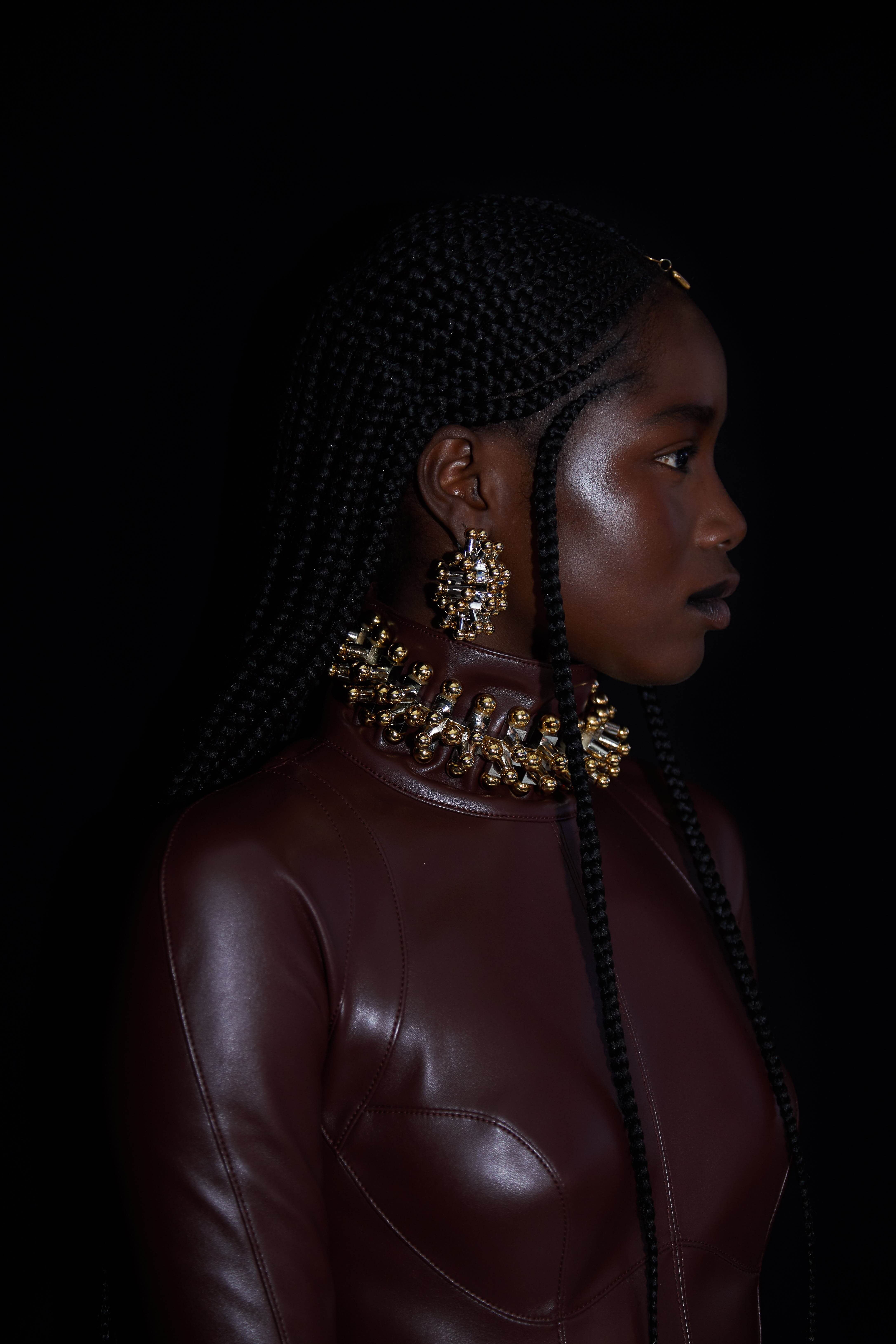 Model wearing large gold earrings and ring necklace