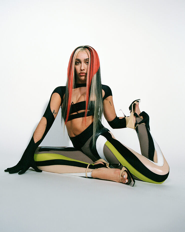 Model with red stripes in hair wearing cut out bodysuit for Mugler