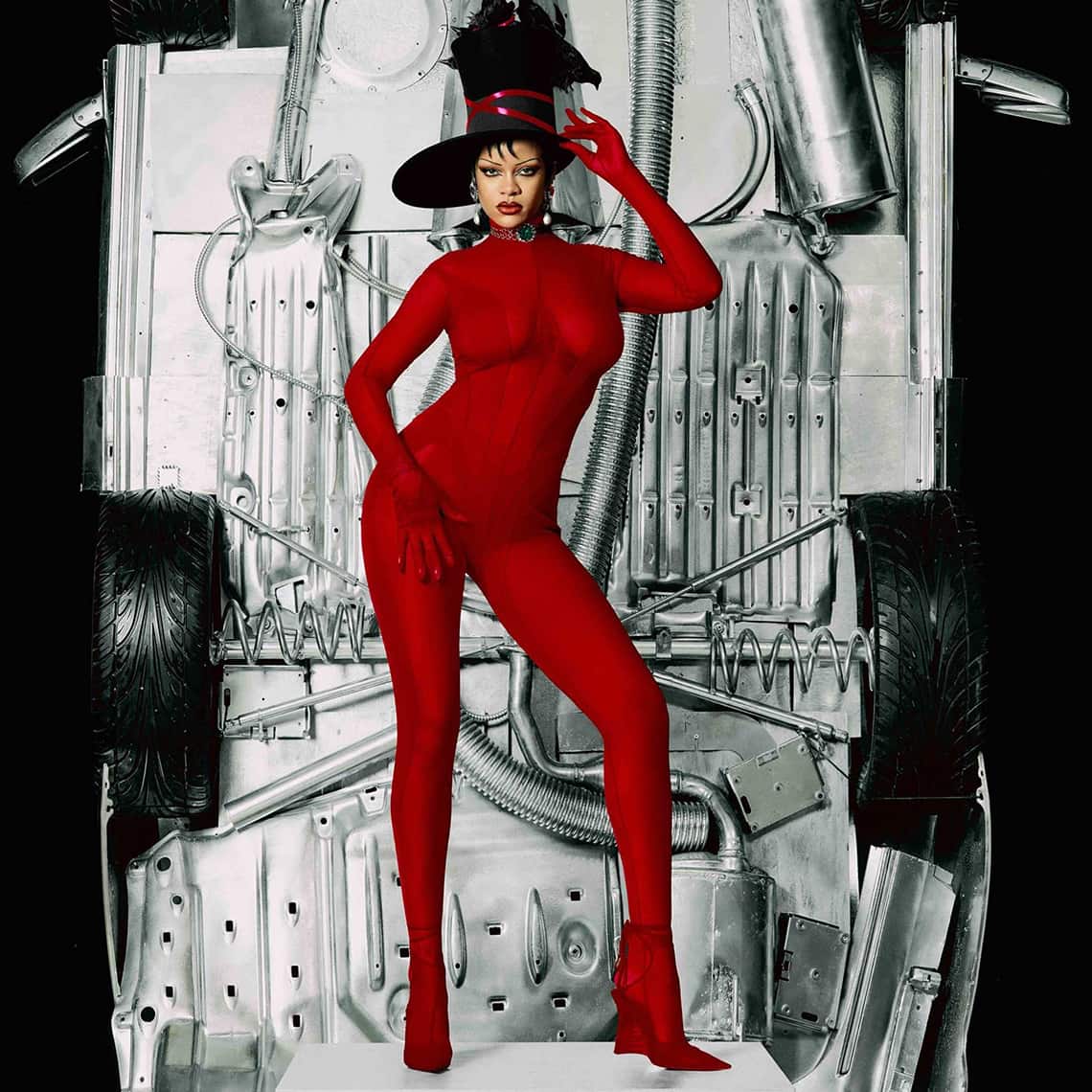 Artist Rihanna wears red full body jumpsuit by Mugler in front of car underside