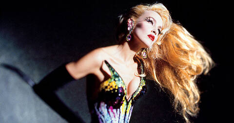 Model with long blonde hair wearing a colorful beaded Mugler corset